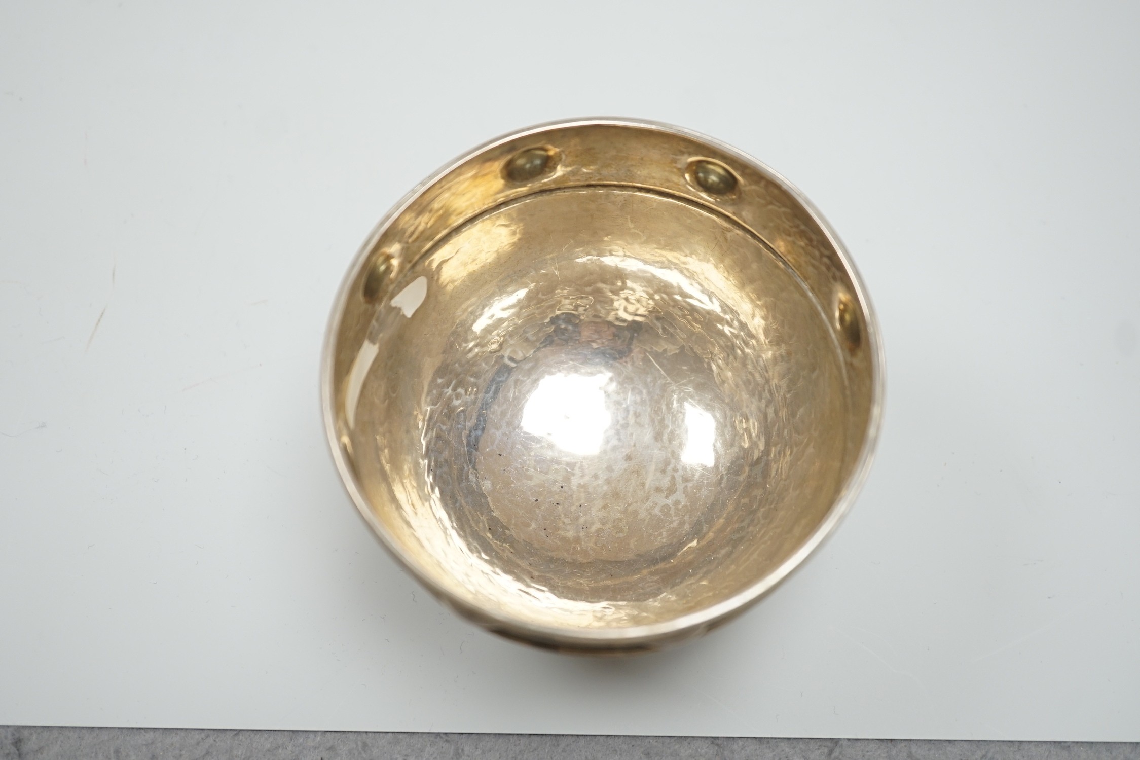 A George V Arts Crafts planished silver bowl, by Albert Edward Jones, Birmingham, 1923, diameter 92mm, on three ball feet, 4oz.